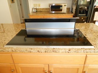 New induction cooktop with retractable downdraft exhaust.